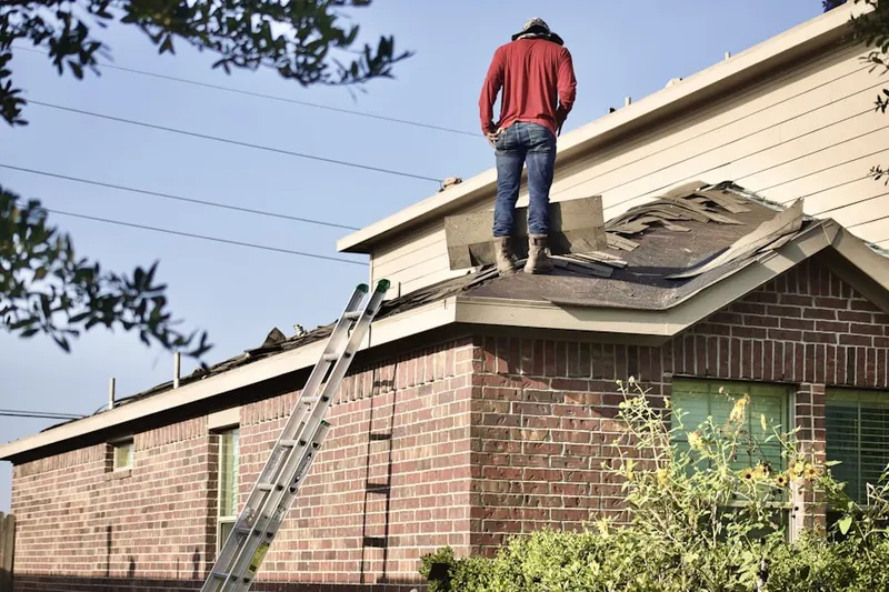 Professional roofer working on a residential roof in Friendswood